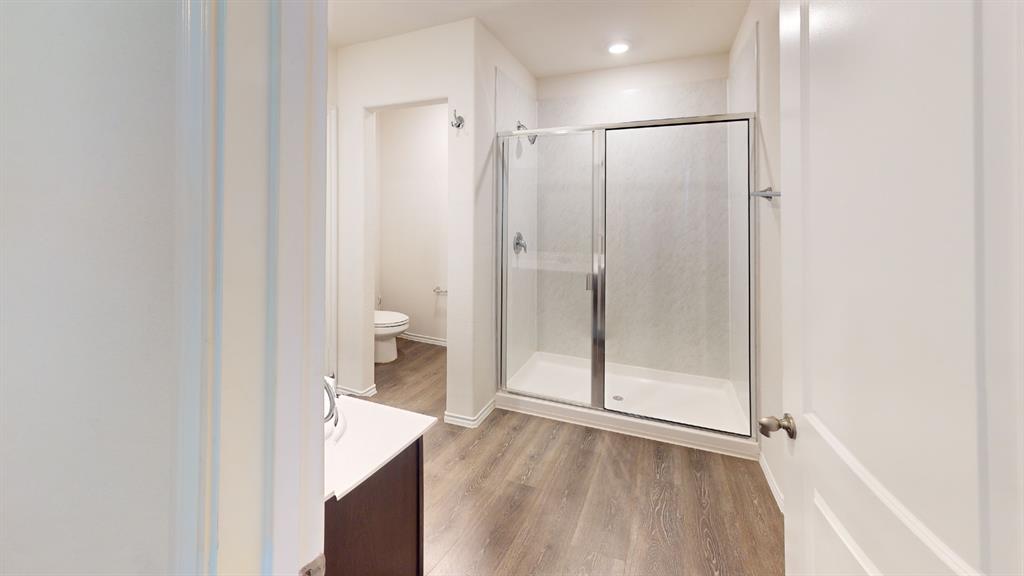 2210 Alamo Road Sherman, TX 75090 - Photo 12 of 17 Full bathroom featuring a glass-enclosed shower with a white pan and textured wall surround, recessed lighting, and wood-finish flooring