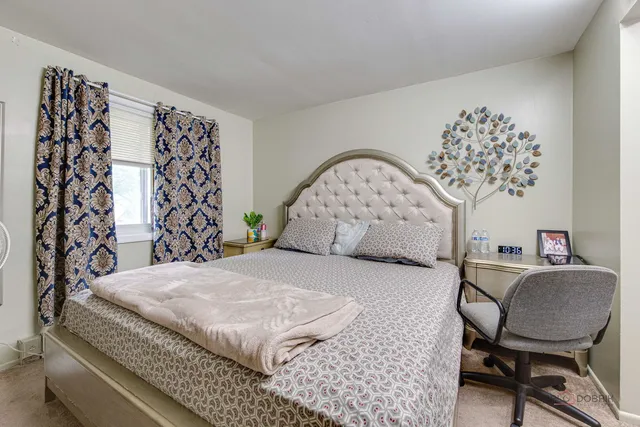 a bedroom with a large bed and a chair