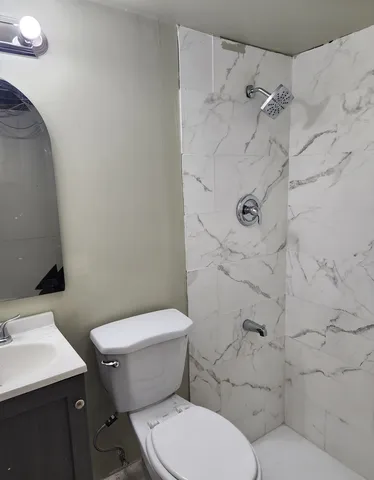 a white toilet sitting next to a bathroom sink