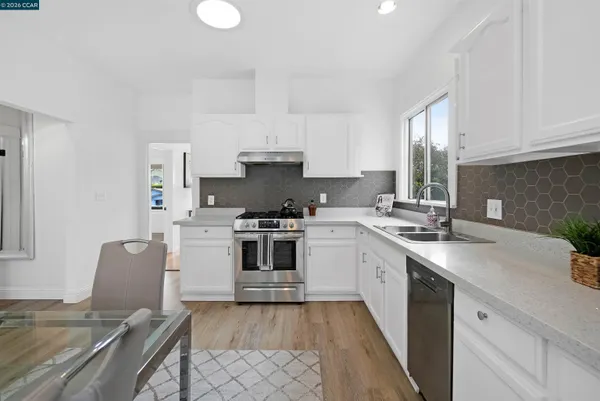 a kitchen with a sink stove and white cabinets