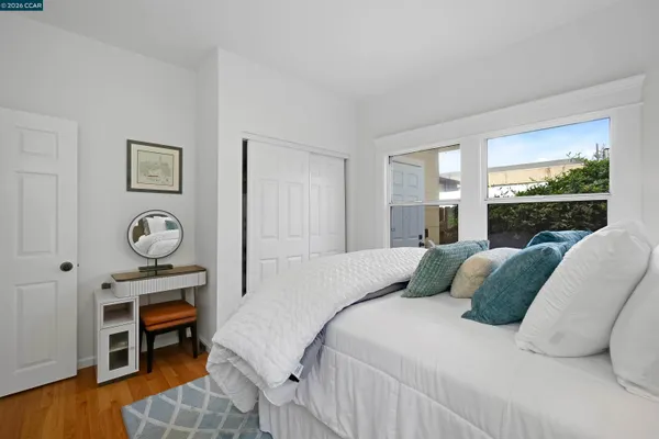 a bedroom with a bed a dresser and large window