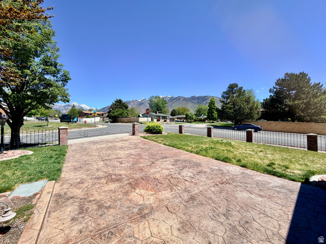 12080 Mill Ridge Circle Sandy, UT 84094 - Photo 2 of 56 Stamped concrete driveway with a brick pillar and wrought iron fence