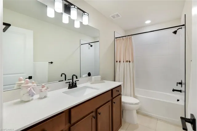 a bathroom with double vanity sink toilet mirror and shower
