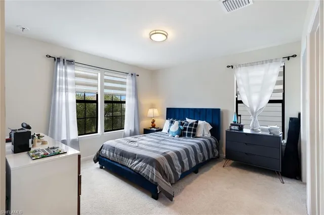 a bedroom with a bed and a dresser next to a window