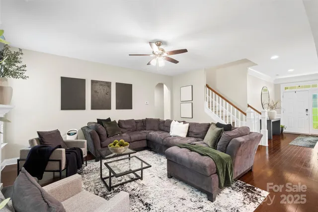 a living room with furniture ceiling fan and wooden floor