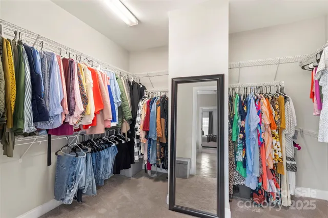 a view of walk in closet with clothes