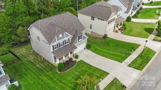 a aerial view of a house next to a big yard and large trees