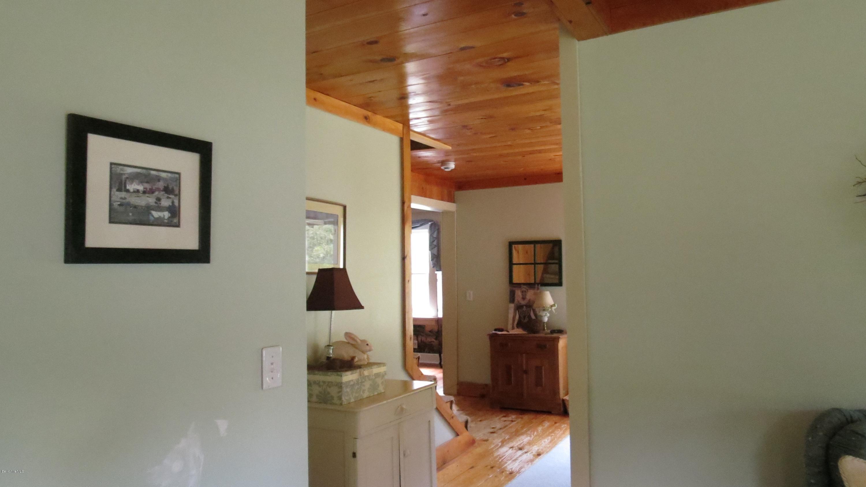 1080 Middle Road Clarksburg, MA 01247 - Photo 14 of 39 a hallway with painting on the wall and a desk