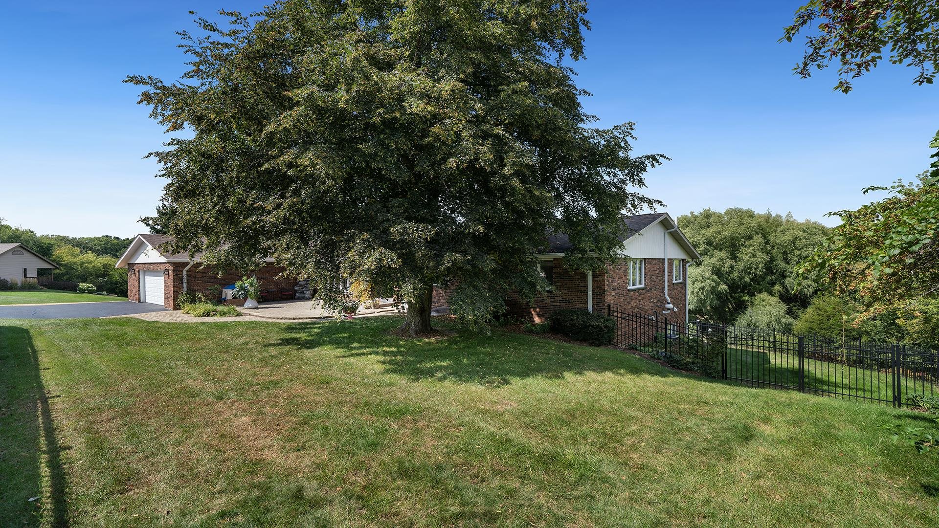 3300 North Silver Ridge Drive Oregon, IL 61061 - Photo 48 of 56 a view of a tree in front of a white house