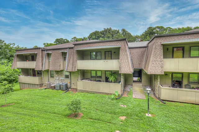 a view of a house with backyard and a tree