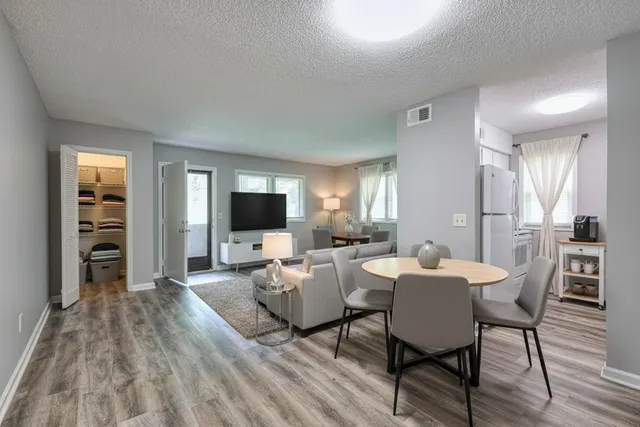a living room with furniture a flat screen tv and kitchen view