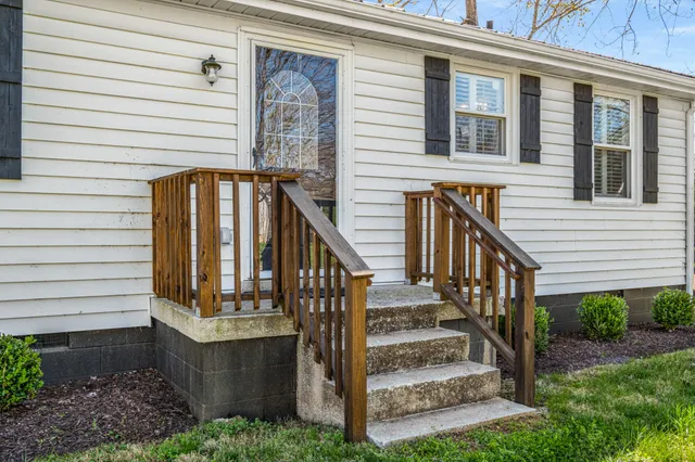 a view of backyard with wooden fence and large tree
