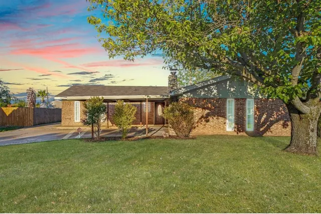 a view of a house with a yard and sitting area