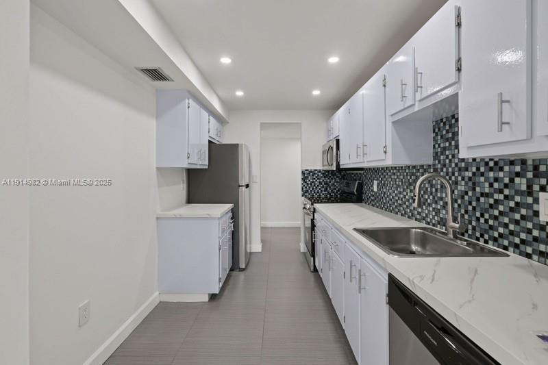 a kitchen with a sink and white cabinets