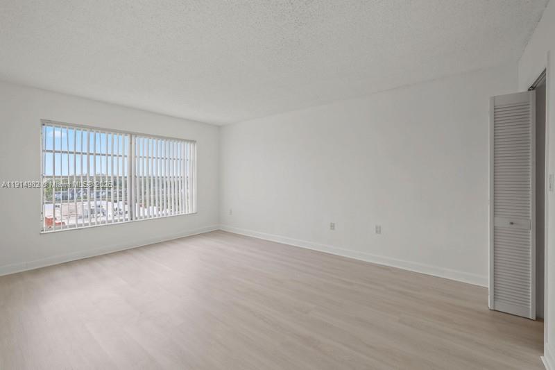4174 Inverrary Drive, Unit 902 Lauderhill, FL 33319 - Photo 15 of 19 a view of an empty room with wooden floor and windows