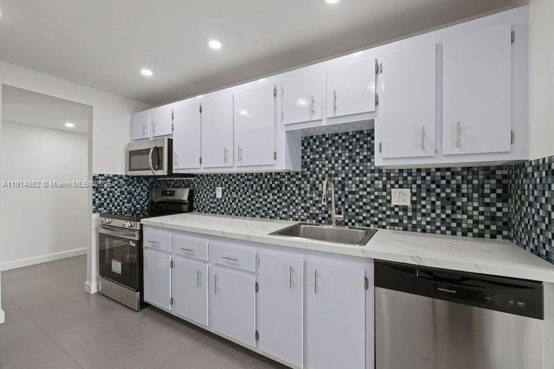 4174 Inverrary Drive, Unit 902 Lauderhill, FL 33319 - Photo 2 of 19 a kitchen with a sink and cabinets