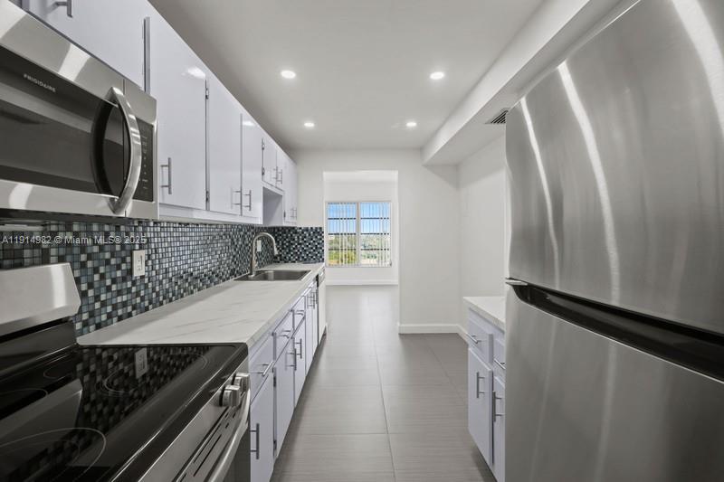 4174 Inverrary Drive, Unit 902 Lauderhill, FL 33319 - Photo 3 of 19 a kitchen with stainless steel appliances a refrigerator a sink and wooden cabinets