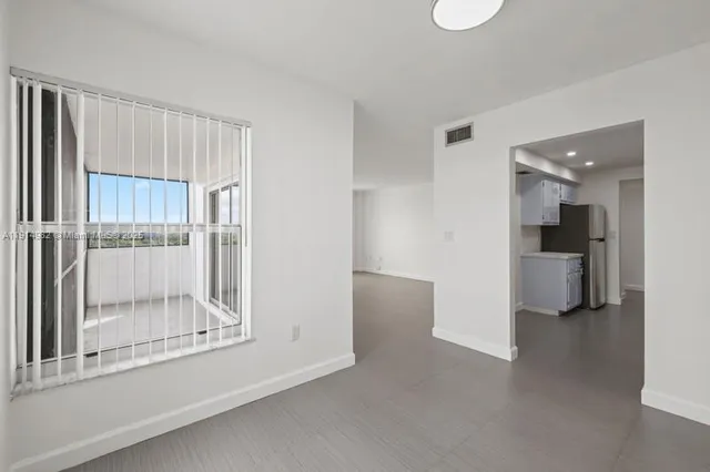 a view of a kitchen with a refrigerator and a sink