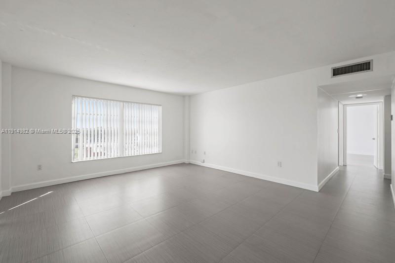 4174 Inverrary Drive, Unit 902 Lauderhill, FL 33319 - Photo 10 of 19 an empty room with wooden floor and windows