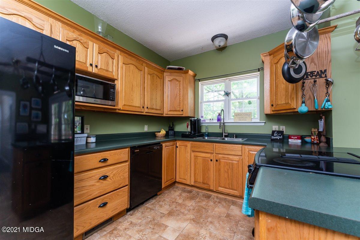 199 Woods Road Juliette, GA 31046 - Photo 15 of 38 a kitchen with granite countertop a stove a sink and a microwave