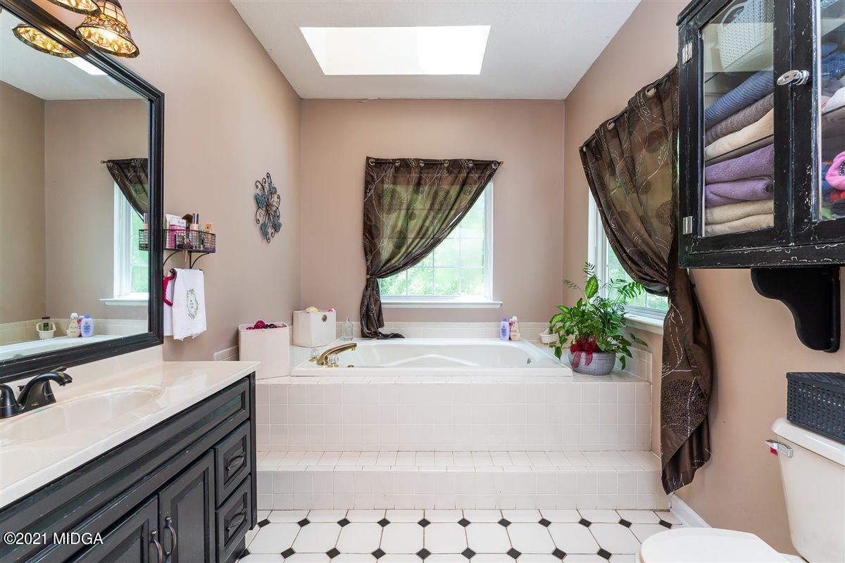 199 Woods Road Juliette, GA 31046 - Photo 22 of 38 a bathroom with a sink a toilet a mirror and shower