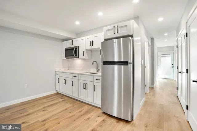 a kitchen with stainless steel appliances a refrigerator sink and microwave