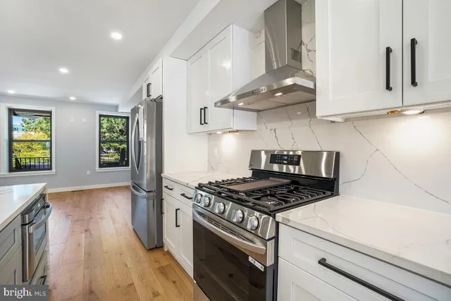 a kitchen with granite countertop a stove and a wooden floors
