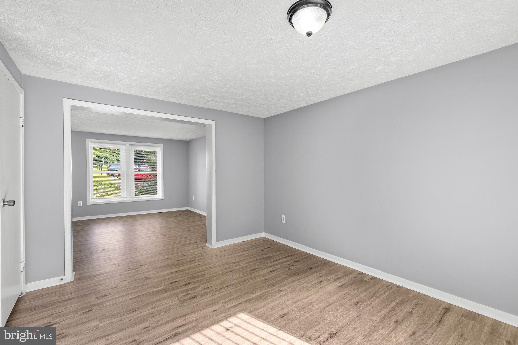 9479 Inaugural Drive King George, VA 22485 - Photo 7 of 26 a view of empty room with wooden floor and window