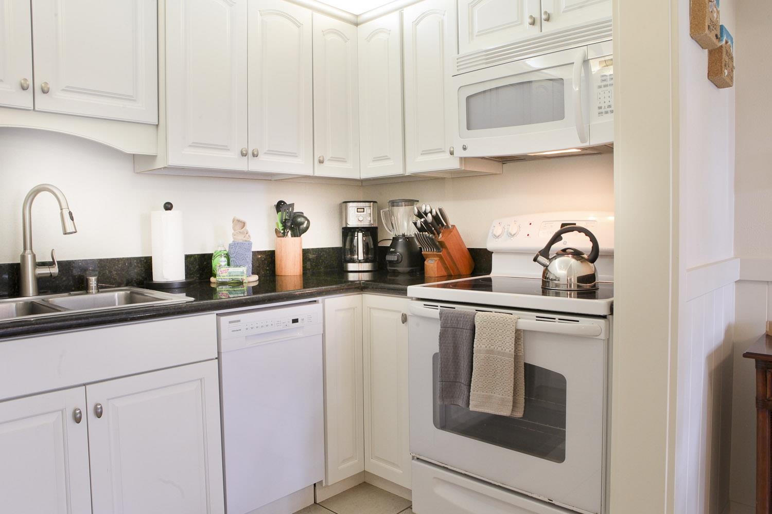 115 North Kihei Road, Unit A3 Kihei, HI 96753 - Photo 6 of 21 a kitchen with white cabinets and white appliances