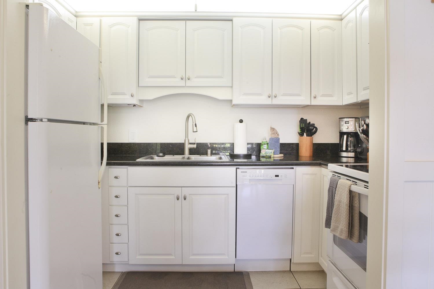115 North Kihei Road, Unit A3 Kihei, HI 96753 - Photo 8 of 21 a kitchen with white cabinets and white appliances