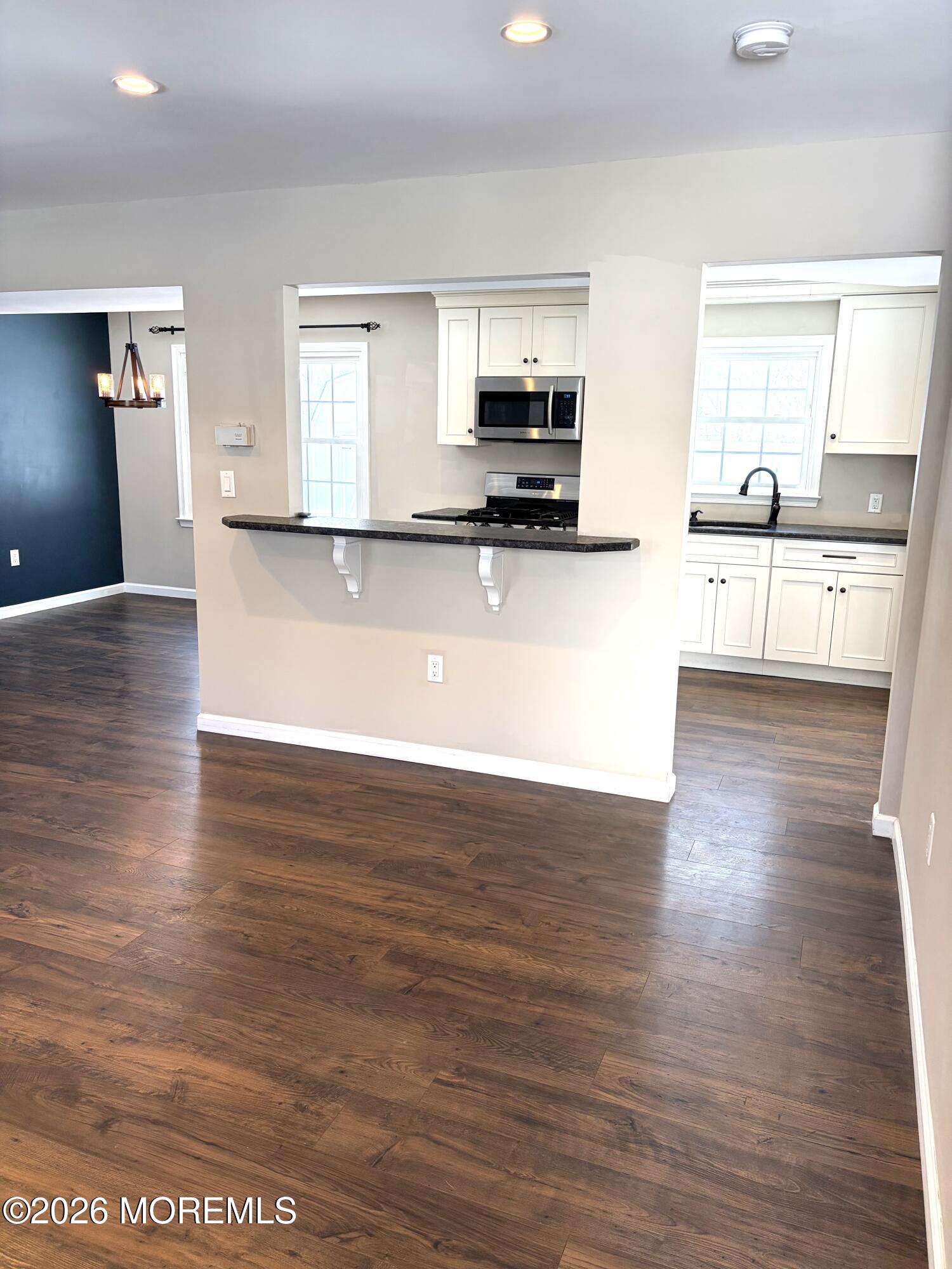 295 Flaam Street Toms River, NJ 08753 - Photo 14 of 30 a view of a kitchen with kitchen island wooden floors and stainless steel appliances