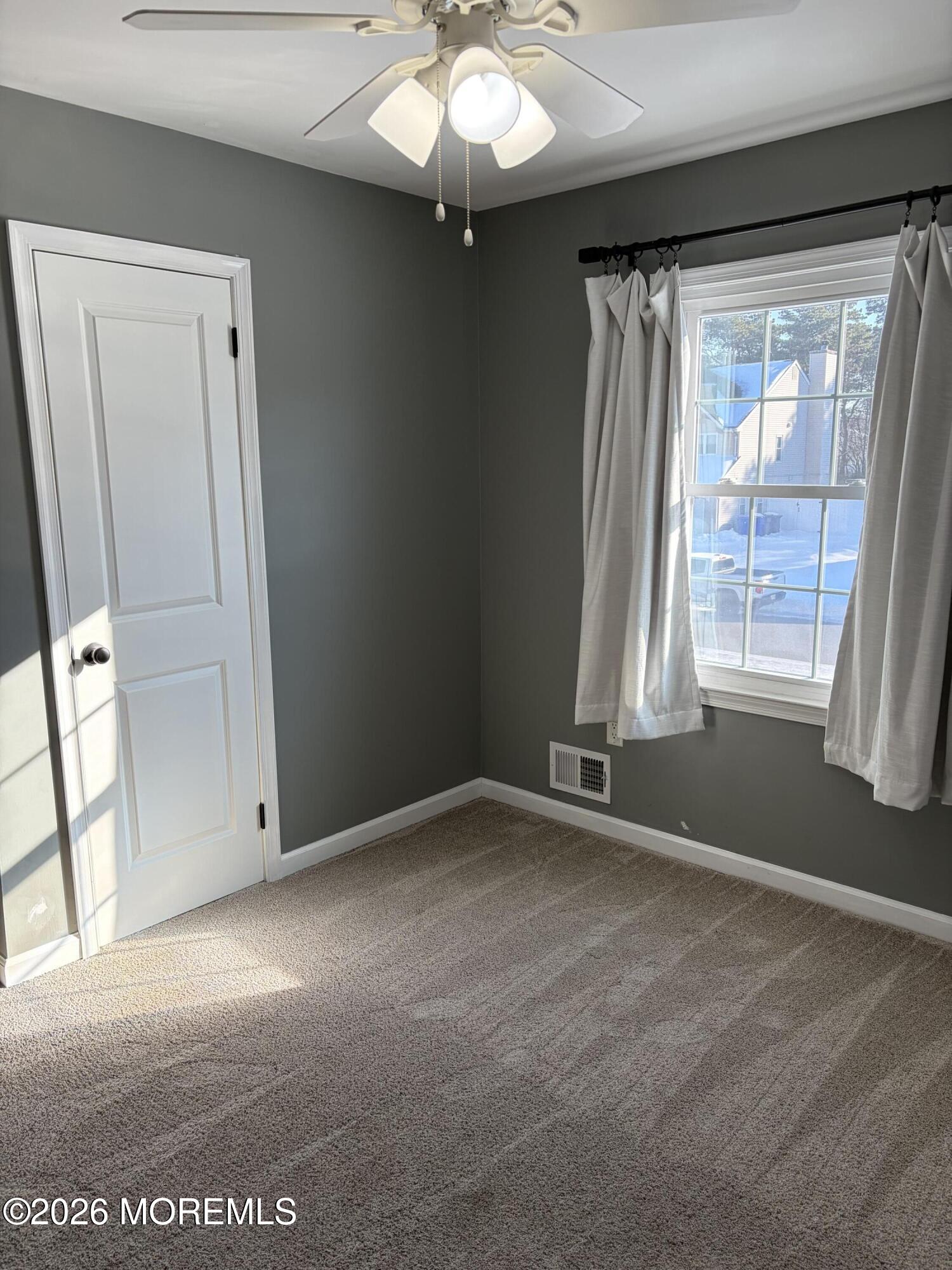 295 Flaam Street Toms River, NJ 08753 - Photo 20 of 30 an empty room with windows and chandelier fan