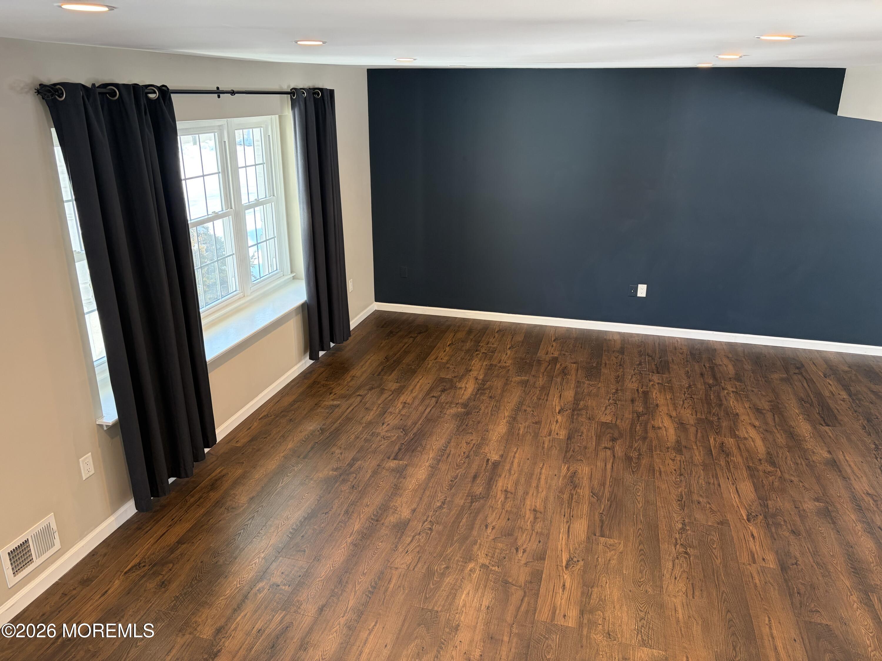 295 Flaam Street Toms River, NJ 08753 - Photo 4 of 30 a view of an empty room with wooden floor and a window