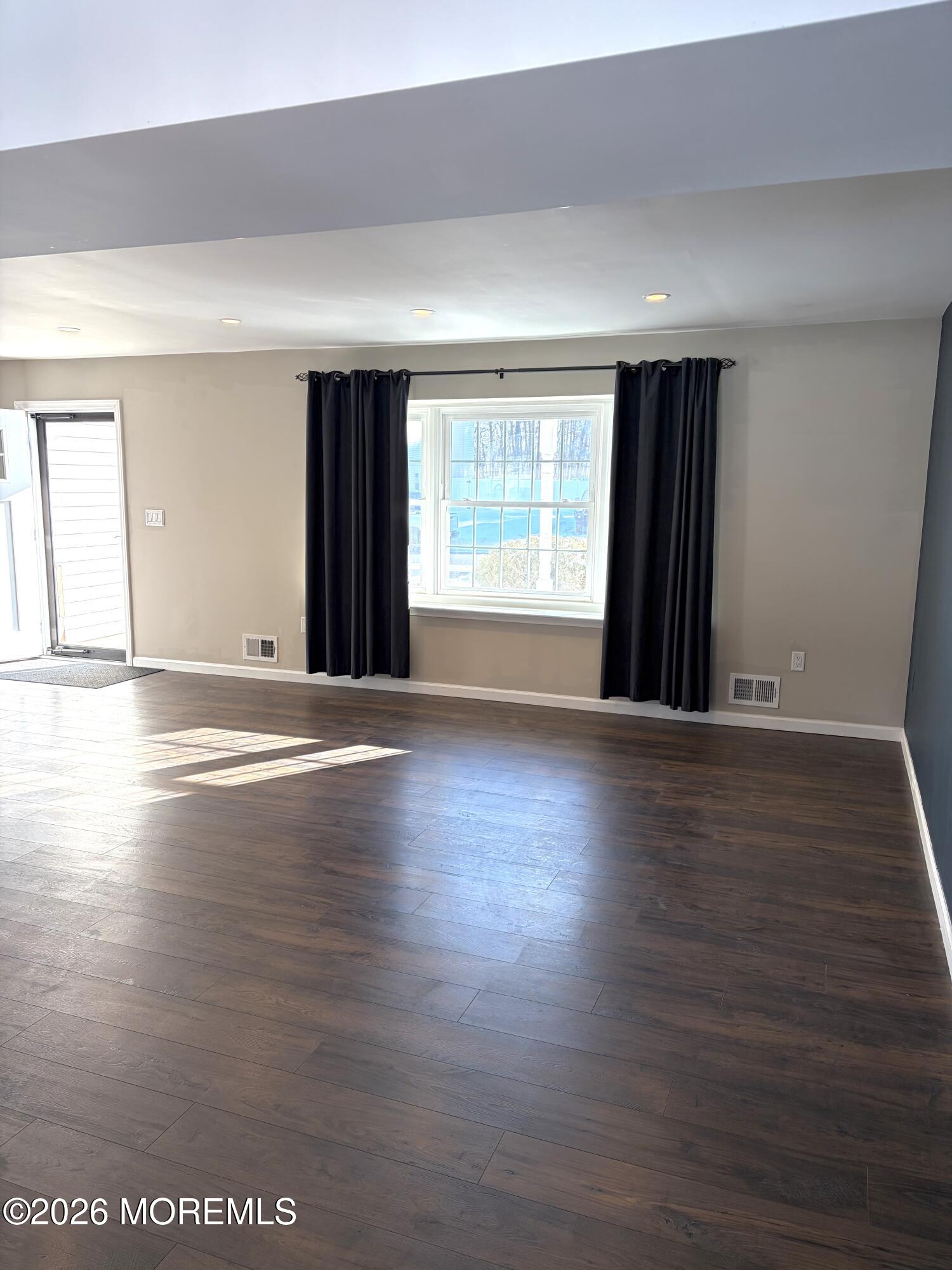 295 Flaam Street Toms River, NJ 08753 - Photo 9 of 30 an empty room with wooden floor and windows