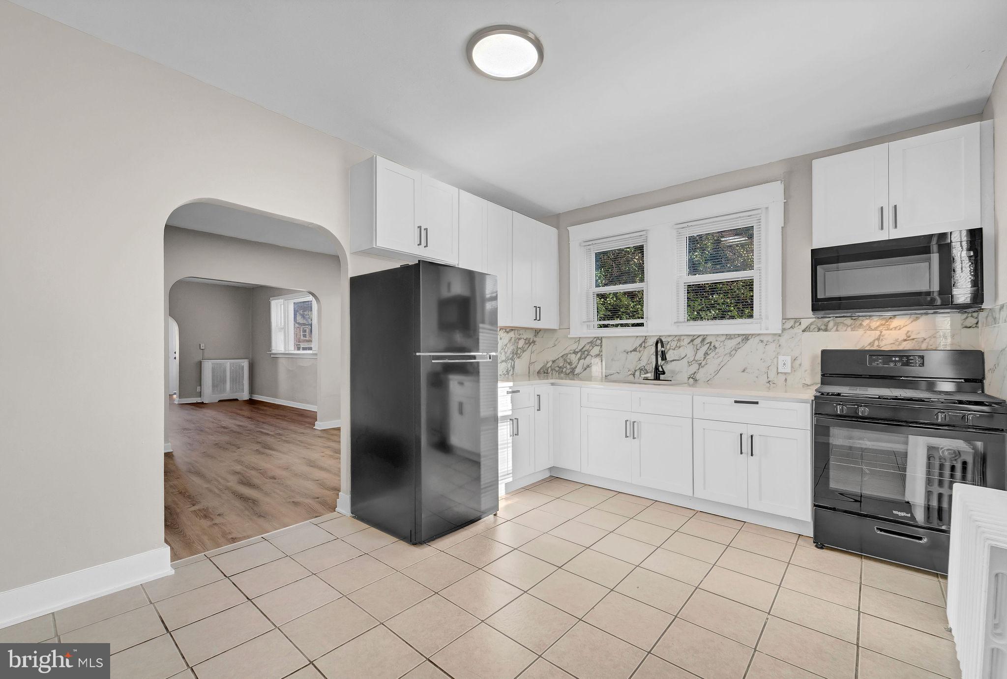 2791 Yorkship Road Camden, NJ 08104 - Photo 12 of 33 a kitchen with granite countertop a refrigerator and a stove top oven