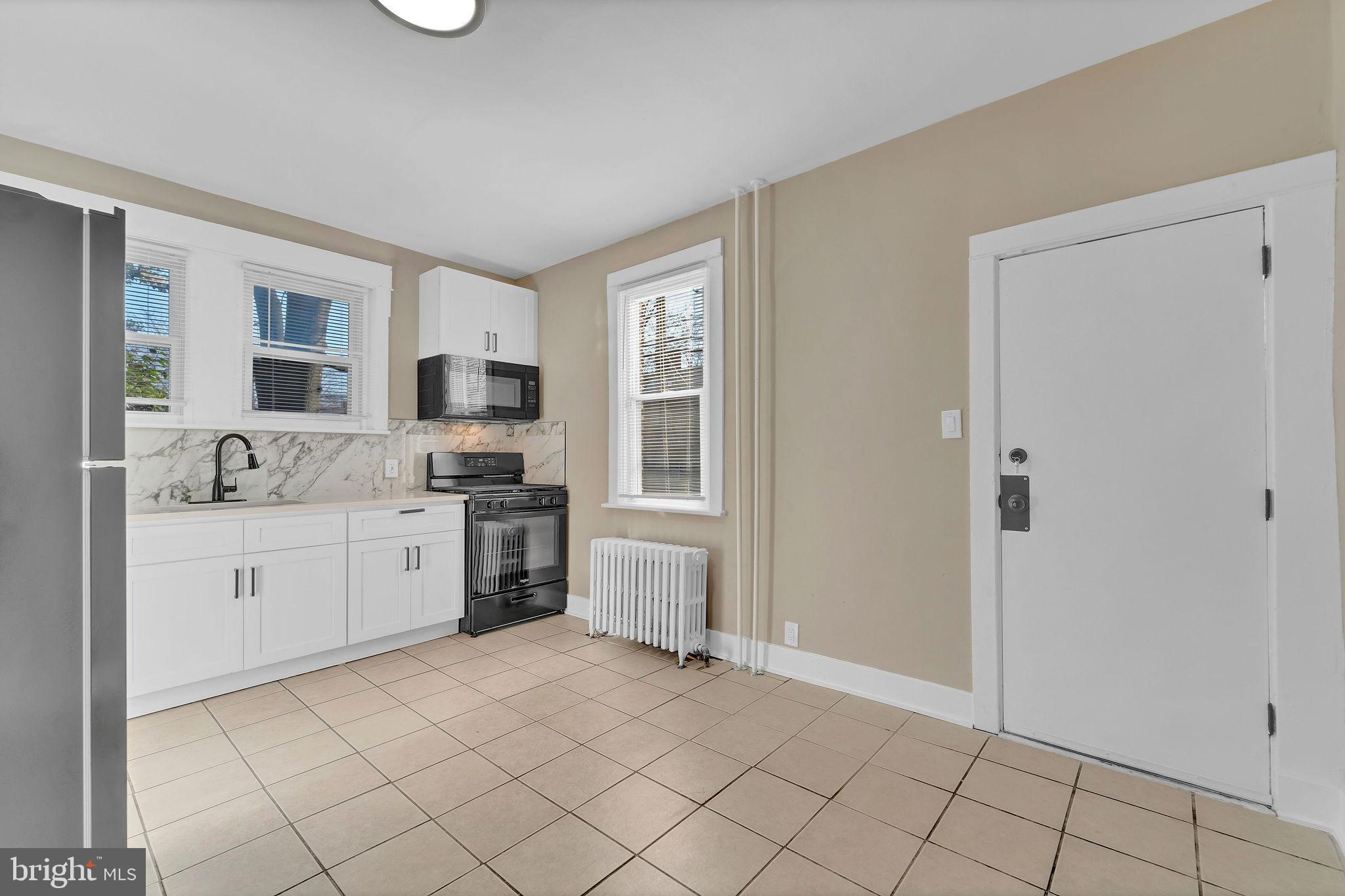 2791 Yorkship Road Camden, NJ 08104 - Photo 13 of 33 a kitchen with granite countertop white cabinets and white appliances