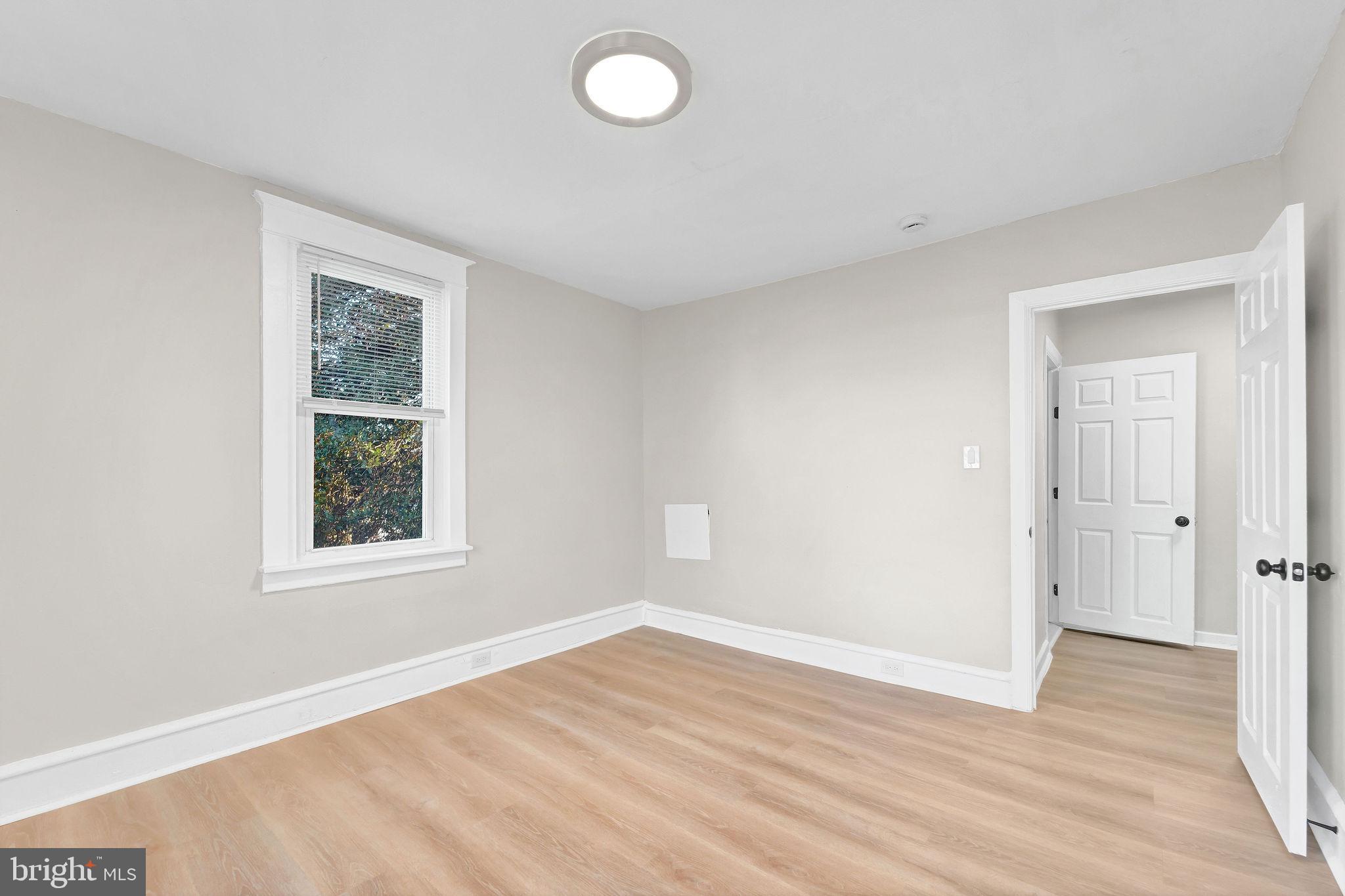 2791 Yorkship Road Camden, NJ 08104 - Photo 18 of 33 an empty room with wooden floor and windows