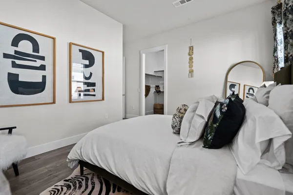 a bedroom with a bed and a painting on the wall