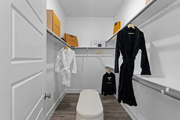 a view of walk in closet with clothes and shoes