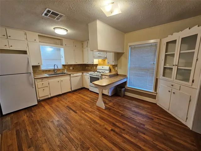 a kitchen with a sink appliances and cabinets