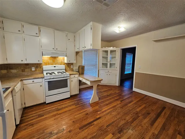 a kitchen with wooden floors and appliances
