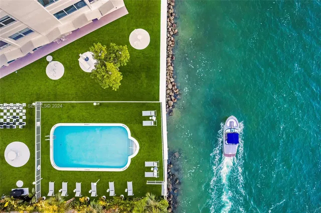 a front view of a building with lot of cars and trees