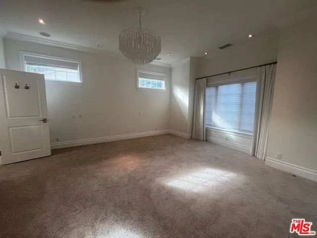 an empty room with windows and ceiling fan