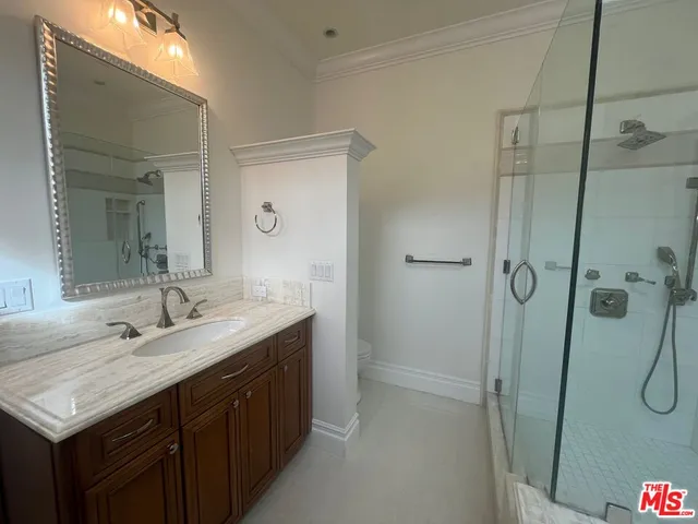 a bathroom with a double vanity sink toilet mirror and shower