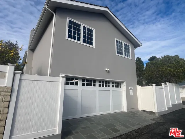 a view of a house with wooden fence