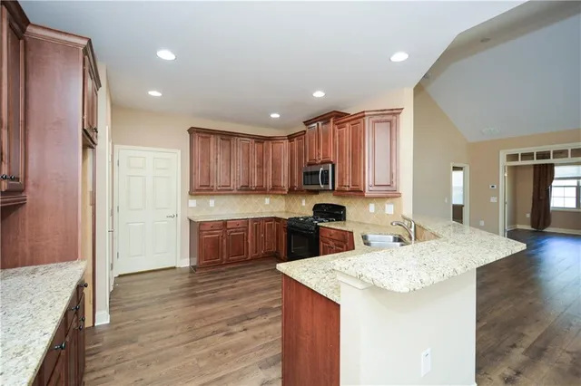 a kitchen with kitchen island granite countertop wooden cabinets and refrigerator