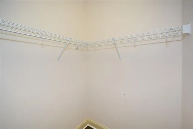 a view of walk in closet with empty racks