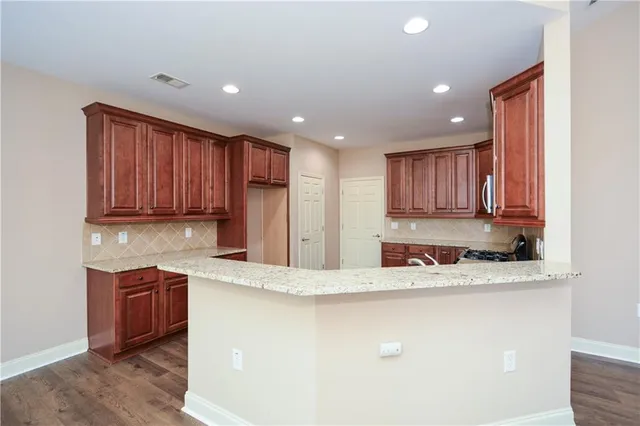 a kitchen with stainless steel appliances granite countertop a sink refrigerator and cabinets