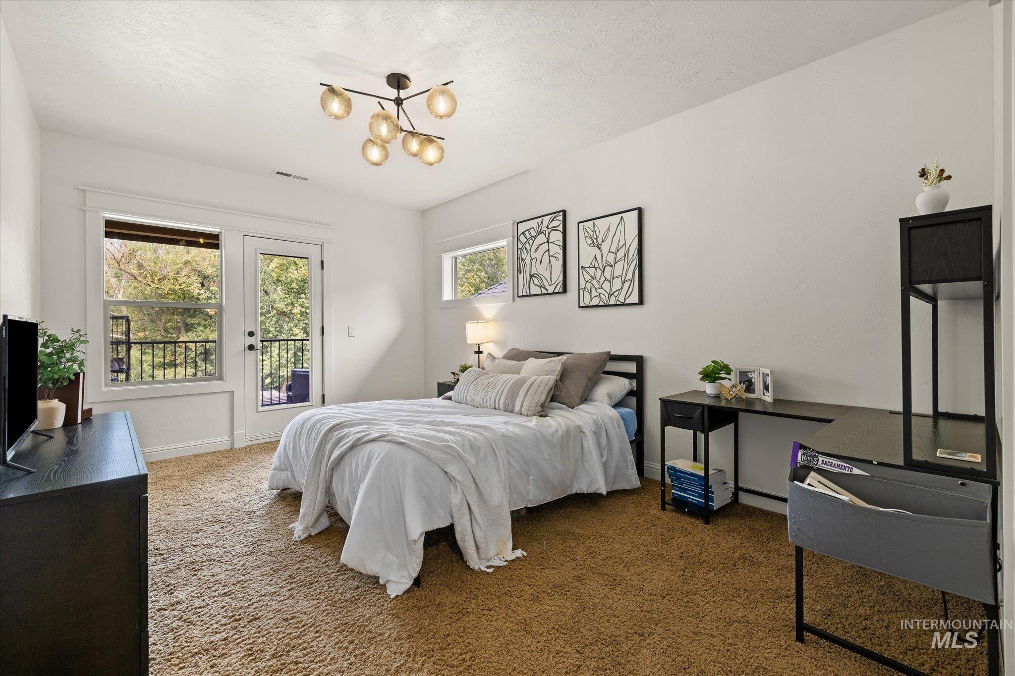 226 East Riversedge Drive Eagle, ID 83616 - Photo 33 of 50 Bedroom featuring carpet floors, access to outside, and a chandelier