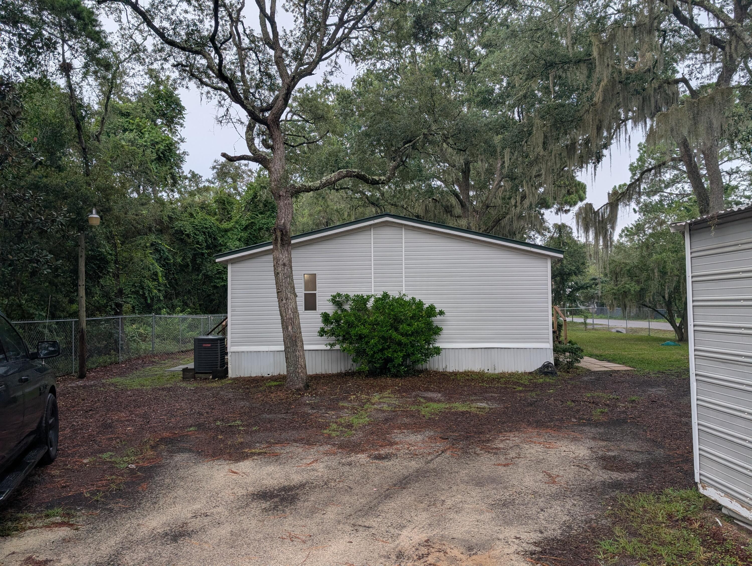 157 East Harborview Road Santa Rosa Beach, FL 32459 - Photo 2 of 27 a view of a house with a yard and garage